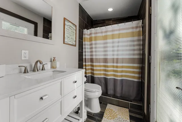 a bathroom with a sink a toilet and shower curtain