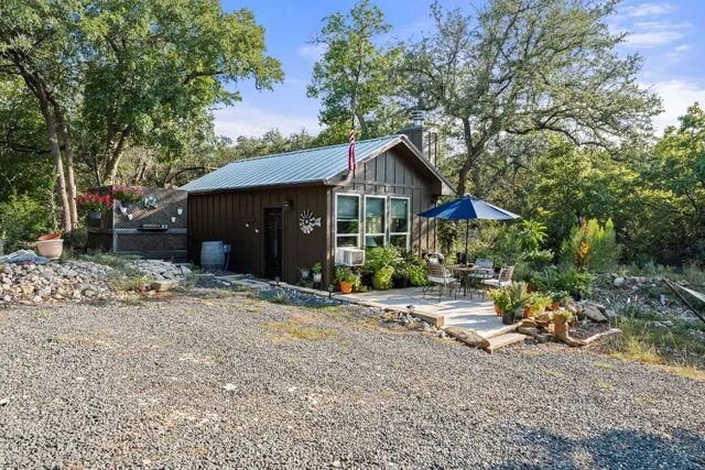 a view of a house with a yard and large tree