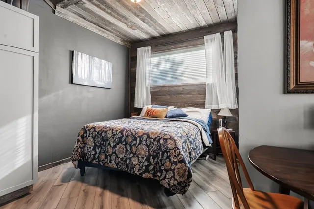 a bedroom with a bed and wooden floor