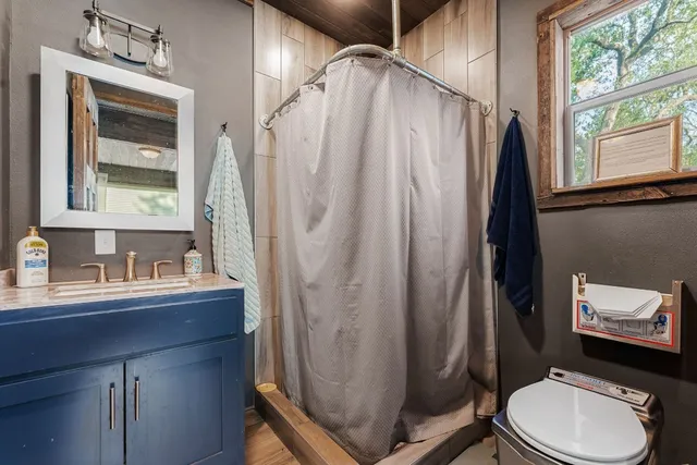 a bathroom with a sink toilet and window