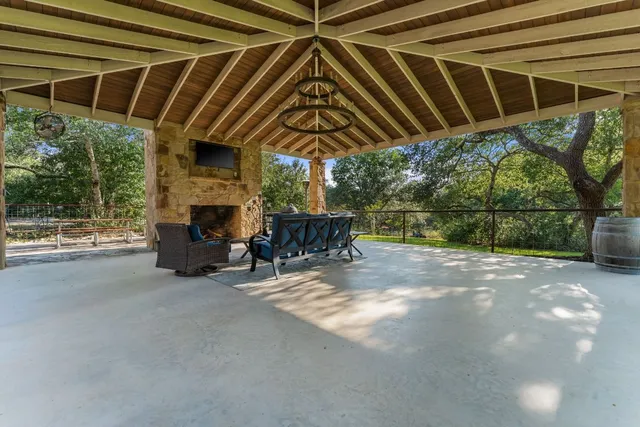 a view of patio with table and chairs under an umbrella with a small yard