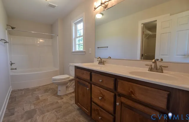 a bathroom with a double vanity sink toilet and shower