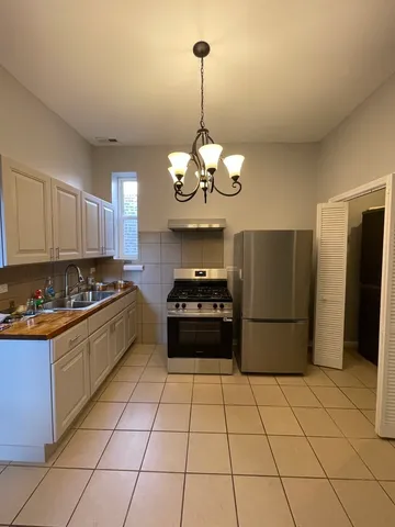 a kitchen with stainless steel appliances granite countertop a stove a refrigerator a sink dishwasher and a refrigerator