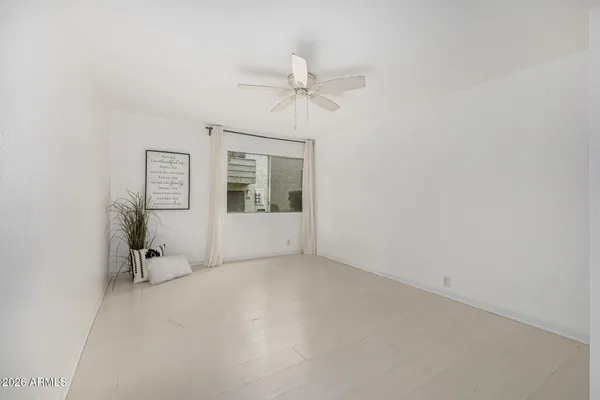 an empty room with a ceiling fan and a window