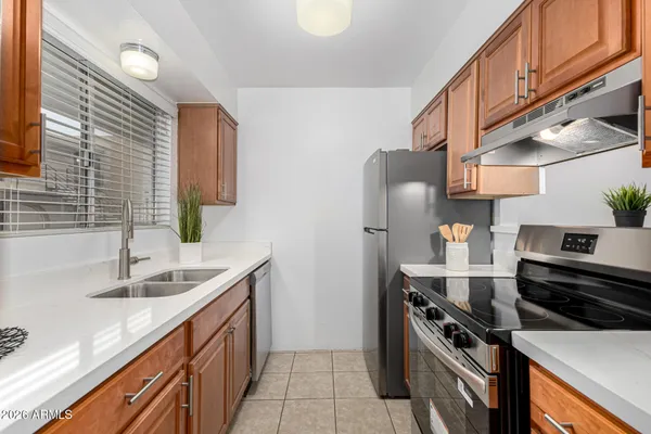 a kitchen with stainless steel appliances granite countertop a refrigerator and a stove