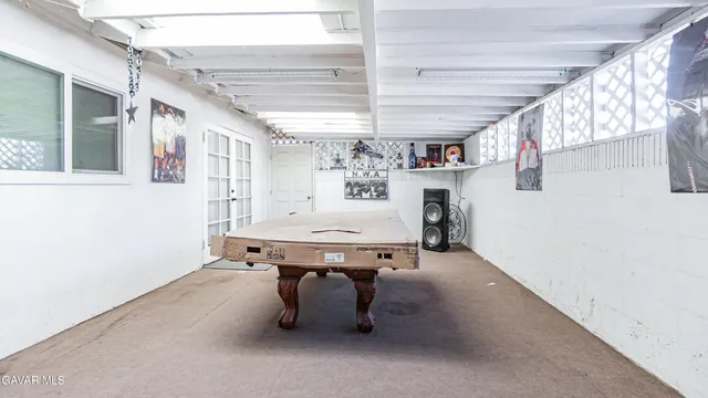 a room with pool table and windows