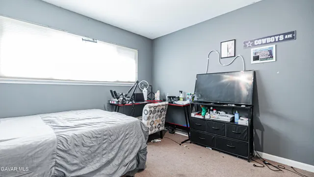 a bedroom with a bed and a flat tv screen