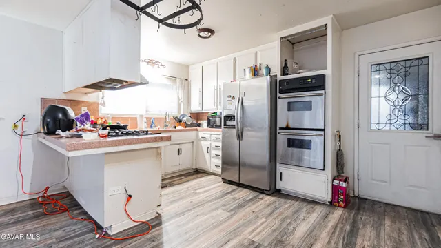 a kitchen with white cabinets and white appliances
