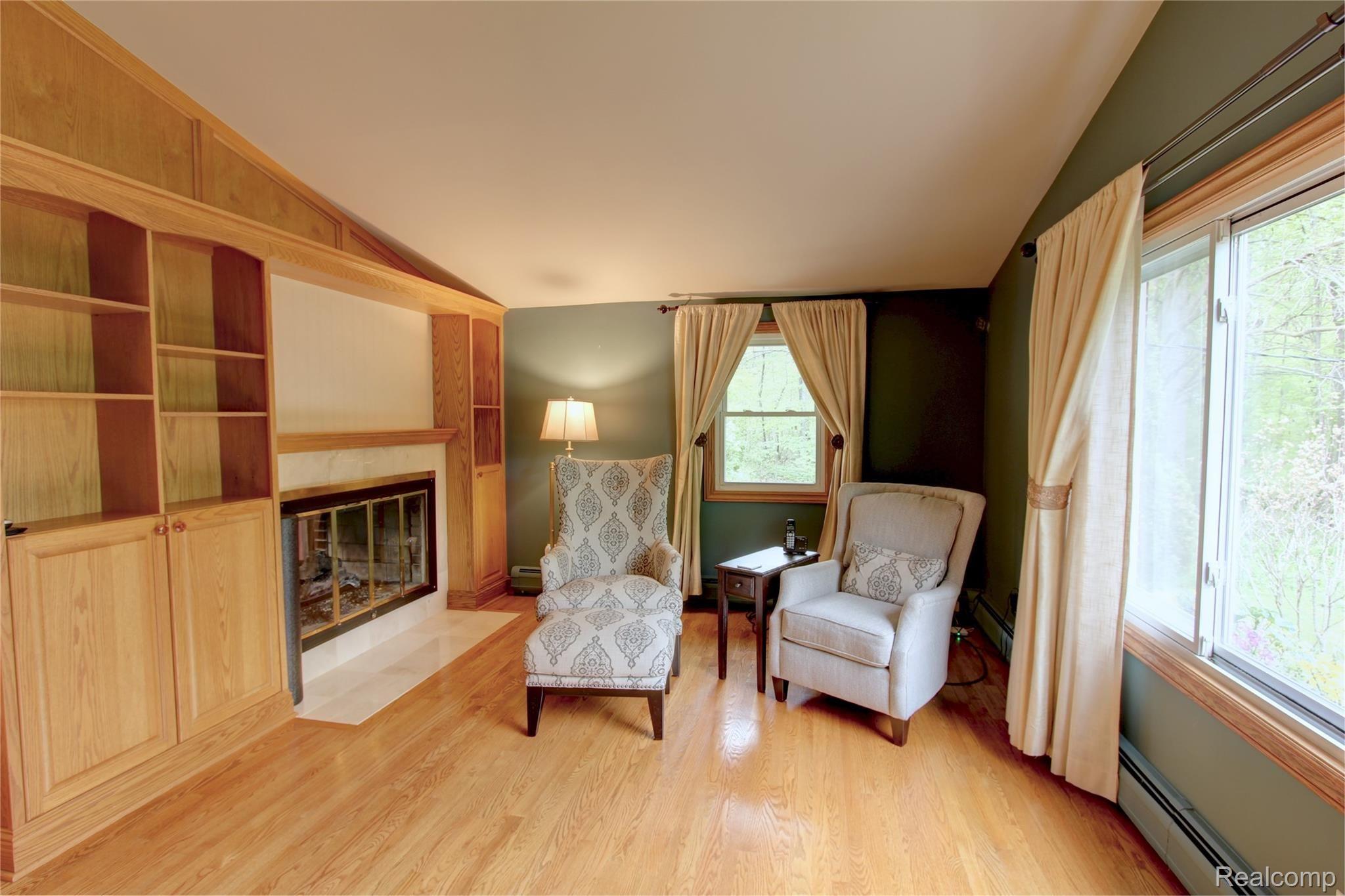 19380 Savage Road Belleville, MI 48111 - Photo 47 of 99 WARM, COZY LIVING ROOM GATHERING SPACE WITH DUAL-SIDED GAS CONVERTED FIREPLACE & BUILT-IN CABINETS/BOOK CASE SUROUND