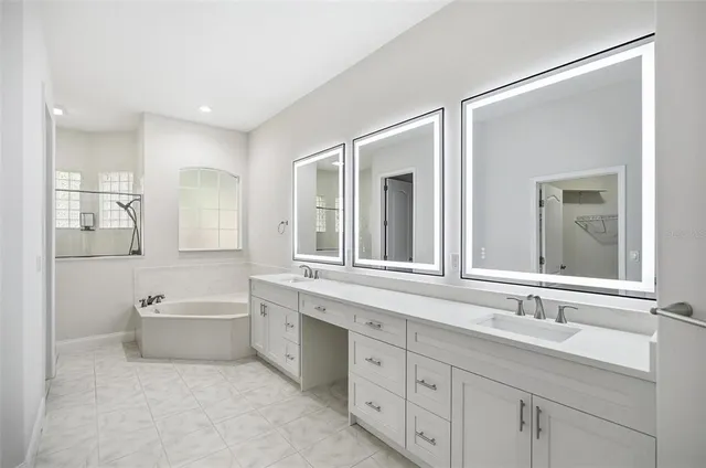 a bathroom with a sink mirror and a window