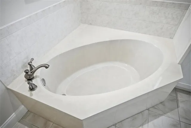 a view of a swimming pool with a bench and trees in the background