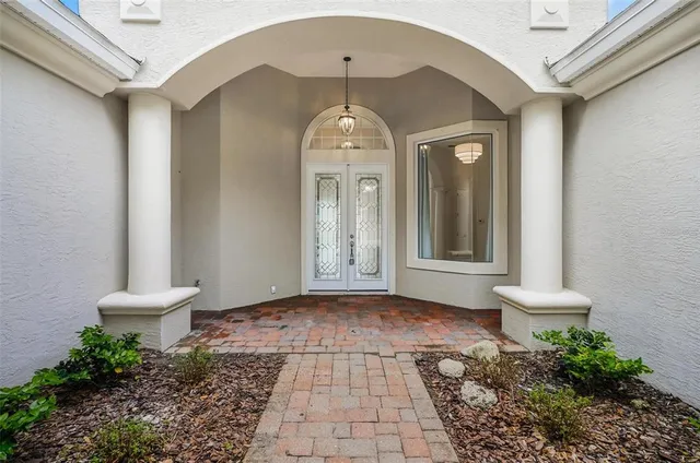 a view of a hallway with wooden floor and a chandelier