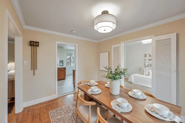 a view of a dining room with furniture a chandelier and wooden floor