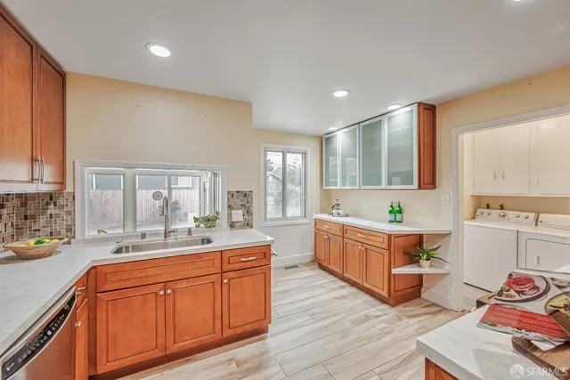 a large kitchen with stainless steel appliances granite countertop a sink and cabinets