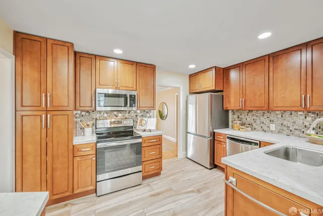 a kitchen with granite countertop stainless steel appliances and wooden cabinets