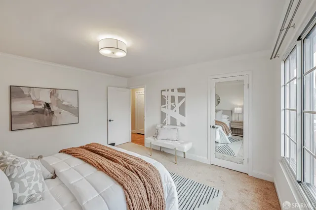 a bedroom with a large bed and a chandelier