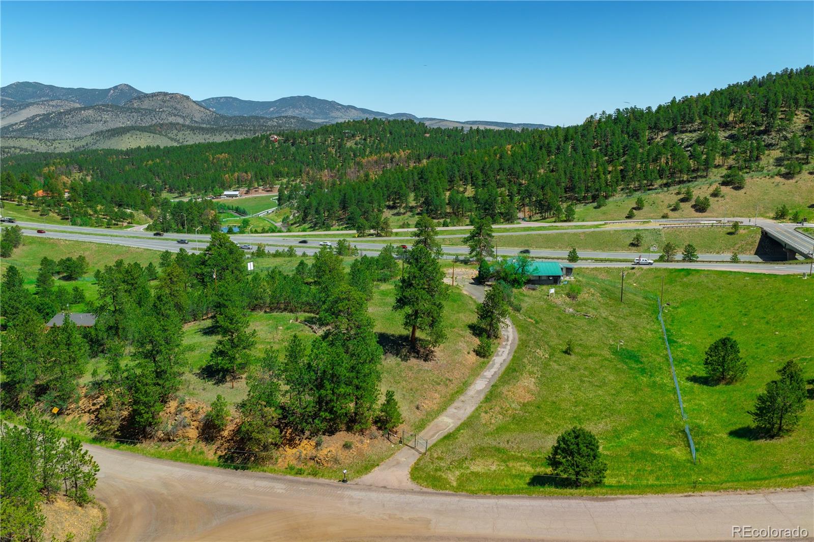 29793 Ruby Ranch Road Evergreen, CO 80439 - Photo 26 of 28 a view of a lush green hillside and houses