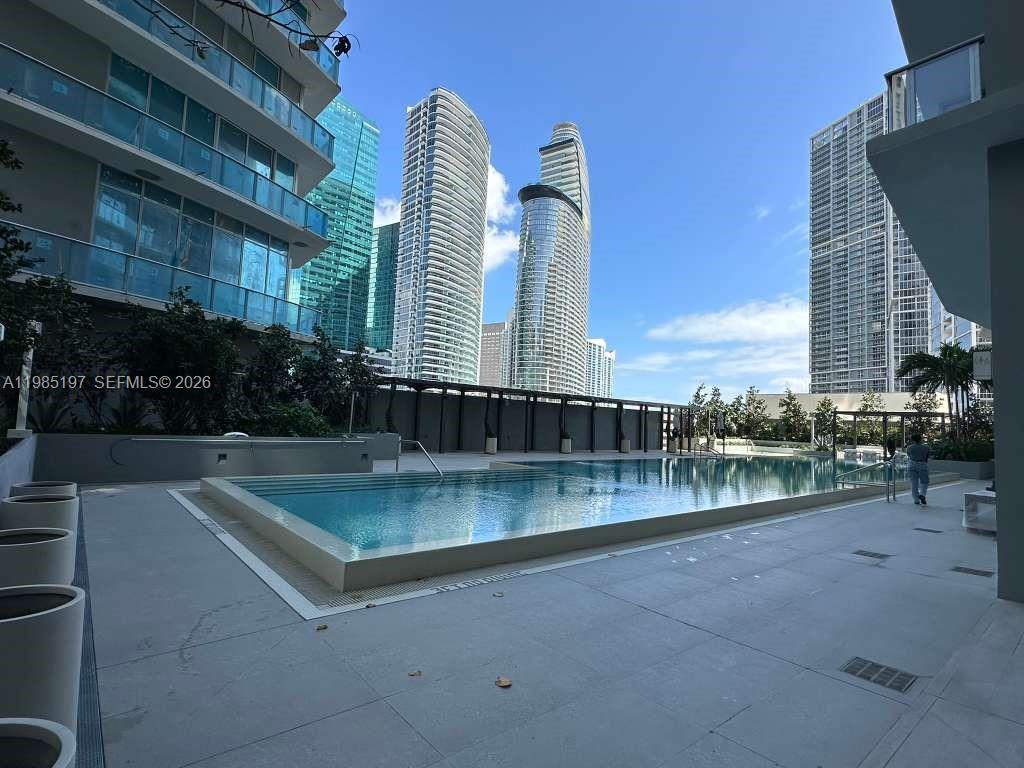 77 Southeast 5th Street, Unit 1513 Miami, FL 33131 - Photo 32 of 49 a view of a swimming pool with outdoor seating and plants