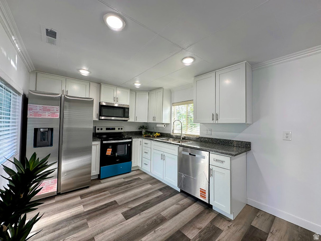 629 North 100 East Logan, UT 84321 - Photo 4 of 11 Modern kitchen featuring white cabinetry, granite-style countertops, and wood-finish flooring
