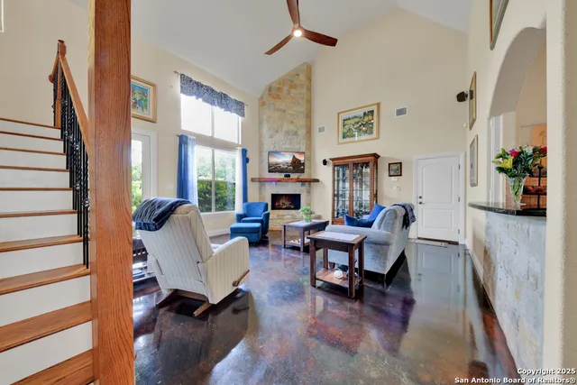 a living room with fireplace furniture and a large window