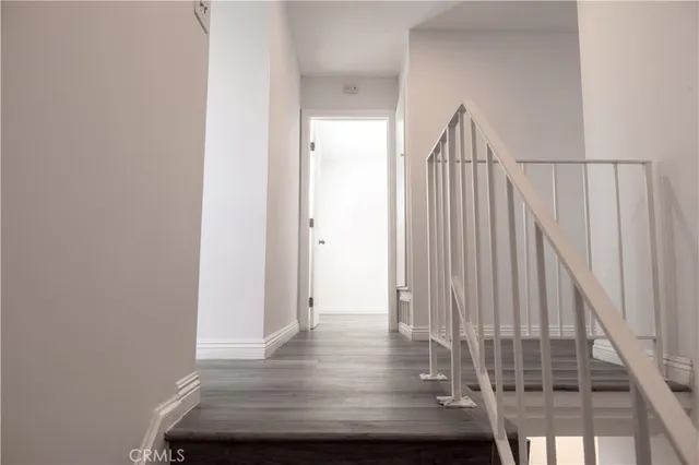 a view of staircase with railing and white walls