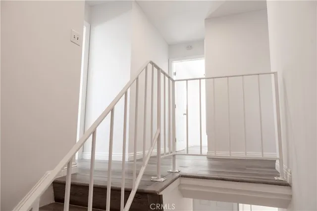 a view of staircase with railing and white walls