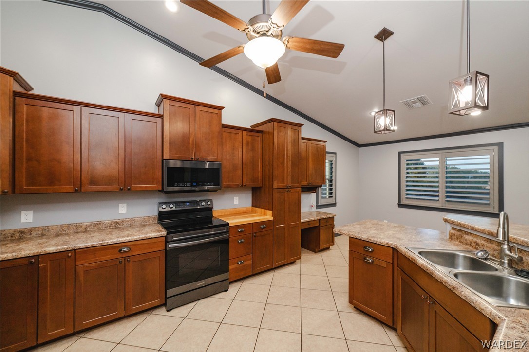 3374 Roma Road Kingman, AZ 86401 - Photo 14 of 64 Kitchen featuring electric range, light countertops, wood finish cabinetry, vaulted ceiling, and pendant lighting