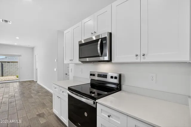 a kitchen with stainless steel appliances a stove a microwave and cabinets