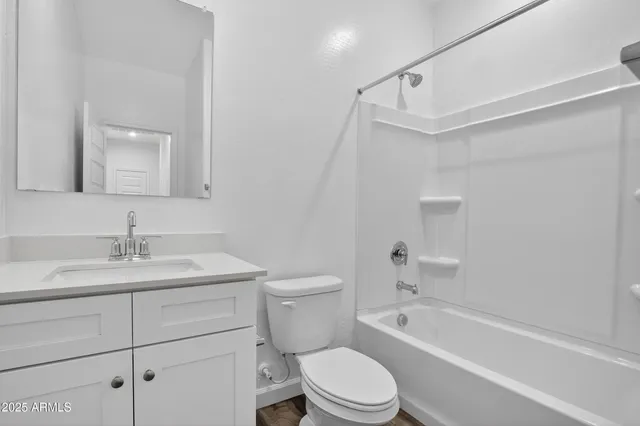 a bathroom with a granite countertop toilet a sink and a bathtub