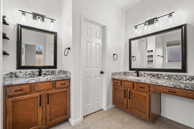 a bathroom with a granite countertop sink vanity and mirror