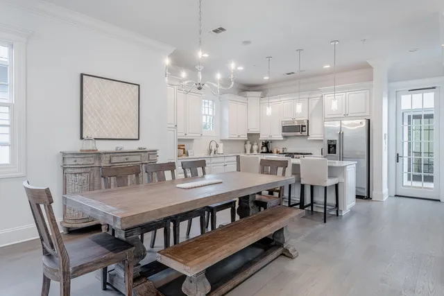 a dining room with stainless steel appliances kitchen island granite countertop a dining table chairs and view living room
