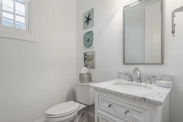 a bathroom with a granite countertop toilet sink and mirror