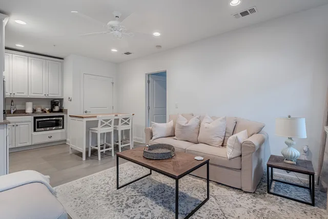 a living room with furniture and kitchen view