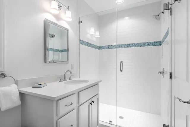 a bathroom with a sink mirror and a shower