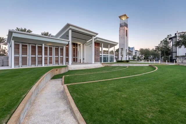a view of a house next to a big yard with a fountain