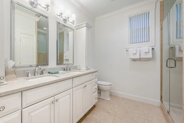 a bathroom with a double vanity sink toilet and mirror