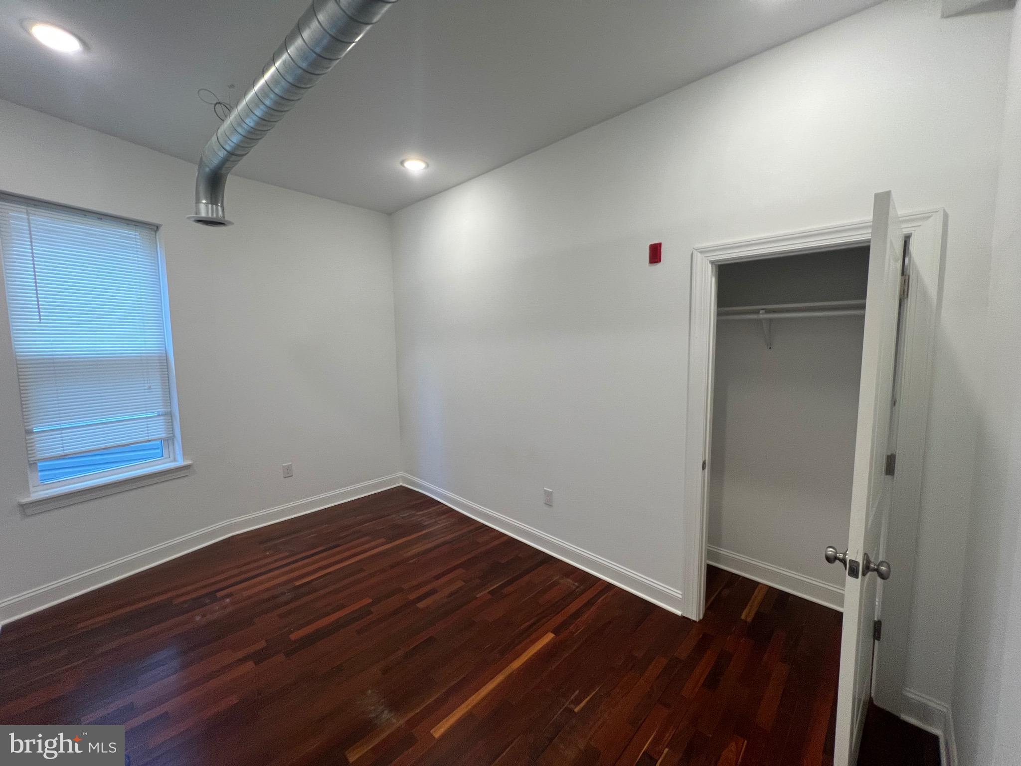 3228 West Diamond Street, Unit 2 Philadelphia, PA 19121 - Photo 5 of 8 a view of an empty room with wooden floor and a window