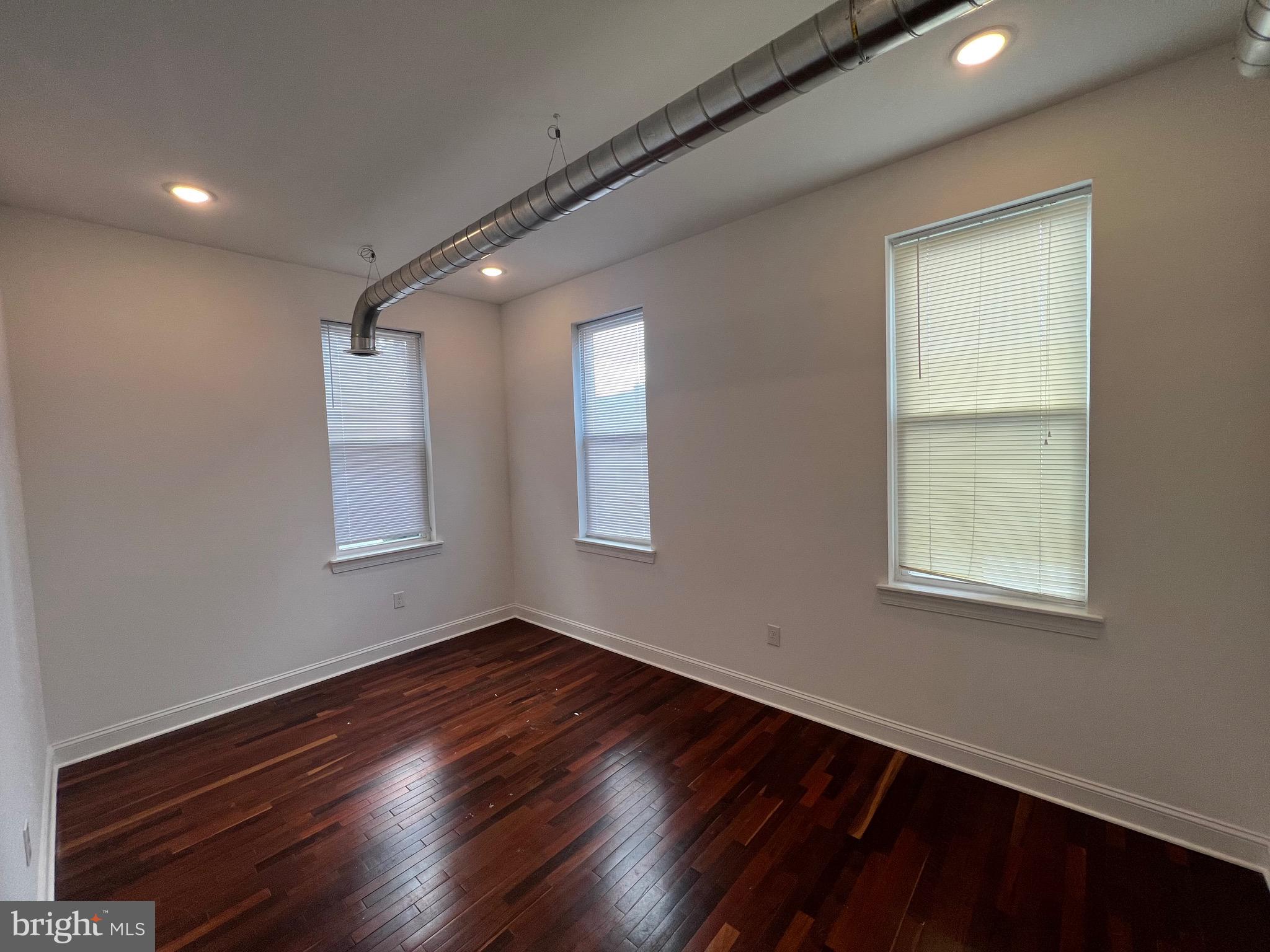 3228 West Diamond Street, Unit 2 Philadelphia, PA 19121 - Photo 8 of 8 a view of an empty room with wooden floor and a window