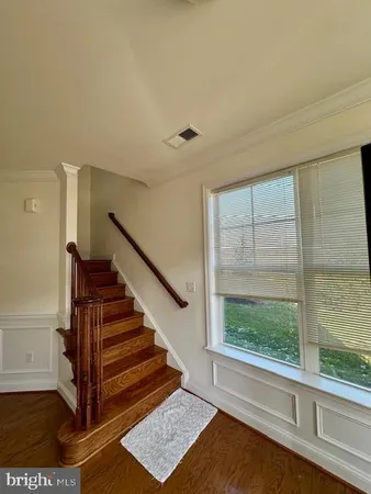 a view of entryway and hall with wooden floor
