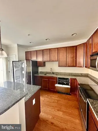 a kitchen with stainless steel appliances granite countertop a stove a sink and a refrigerator