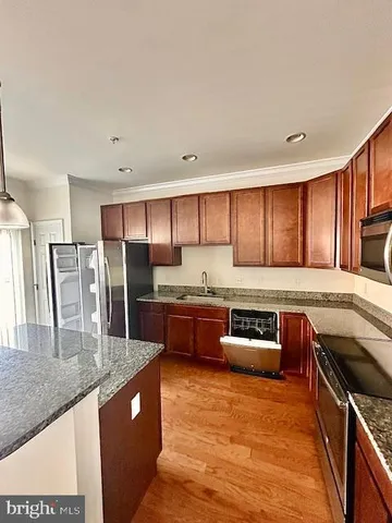 a kitchen with stainless steel appliances granite countertop a stove a sink and a refrigerator