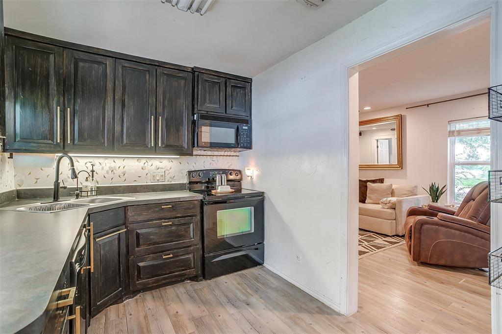 3147 Tin Top Road Weatherford, TX 76087 - Photo 13 of 40 a kitchen with stainless steel appliances a stove a sink and a refrigerator