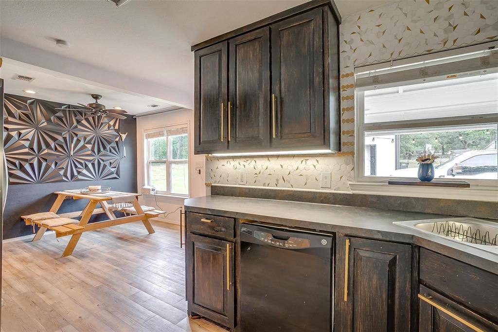 3147 Tin Top Road Weatherford, TX 76087 - Photo 15 of 40 a kitchen with granite countertop a refrigerator and a sink