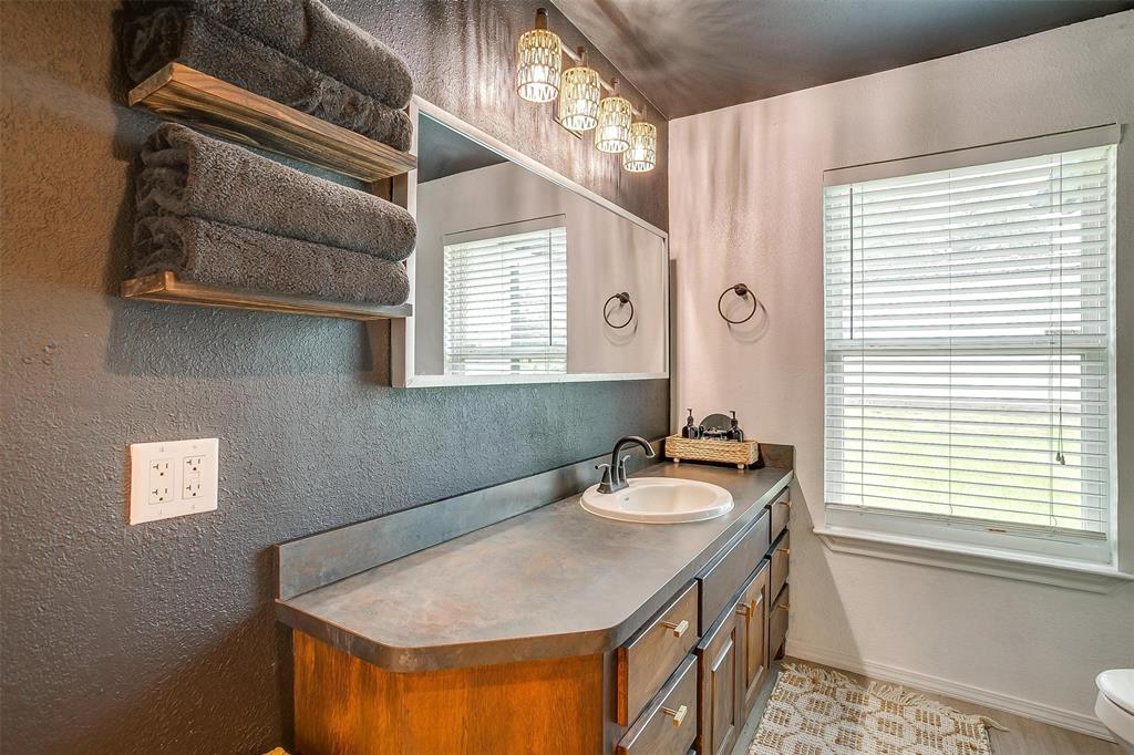 3147 Tin Top Road Weatherford, TX 76087 - Photo 33 of 40 a bathroom with a tub sink and mirror