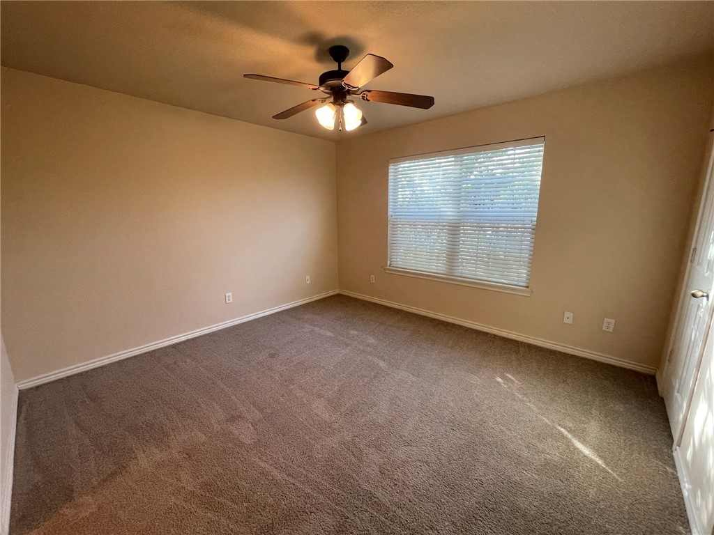 3522 Paloma Ridge Drive College Station, TX 77845 - Photo 5 of 10 an empty room with a chandelier fan and windows