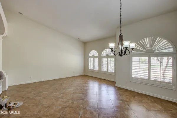 a view of empty room with wooden floor and chandelier