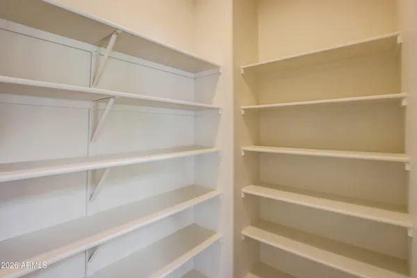 a view of walk in closet with empty racks