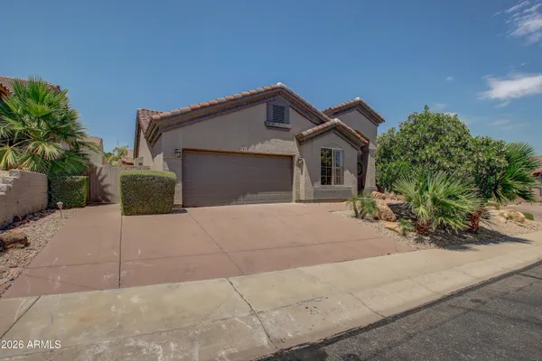 a front view of a house with a yard and a garage