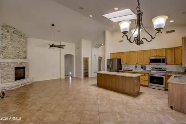 a kitchen with stainless steel appliances granite countertop a stove top oven a sink a window and chairs