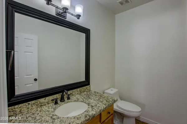 a bathroom with a granite countertop sink and a mirror